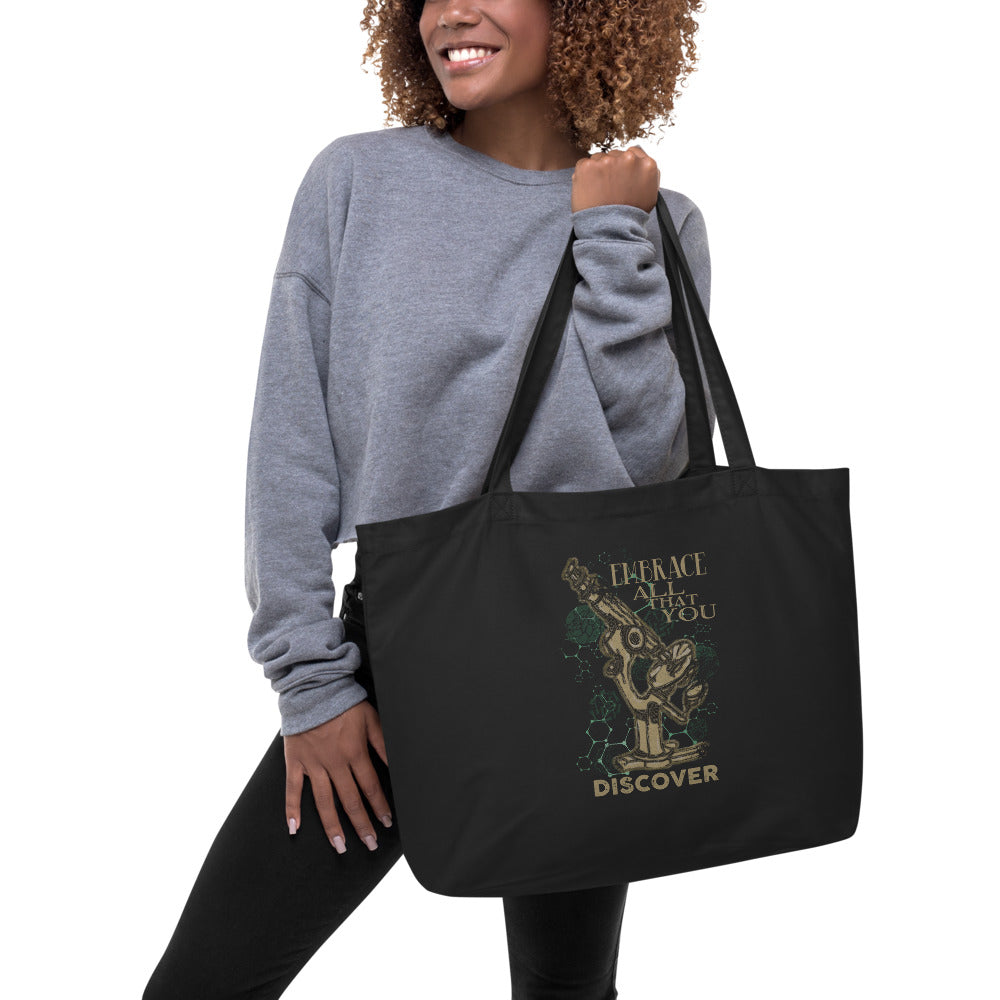 woman holding large organic cotton black tote bag Embrace All That You Discover